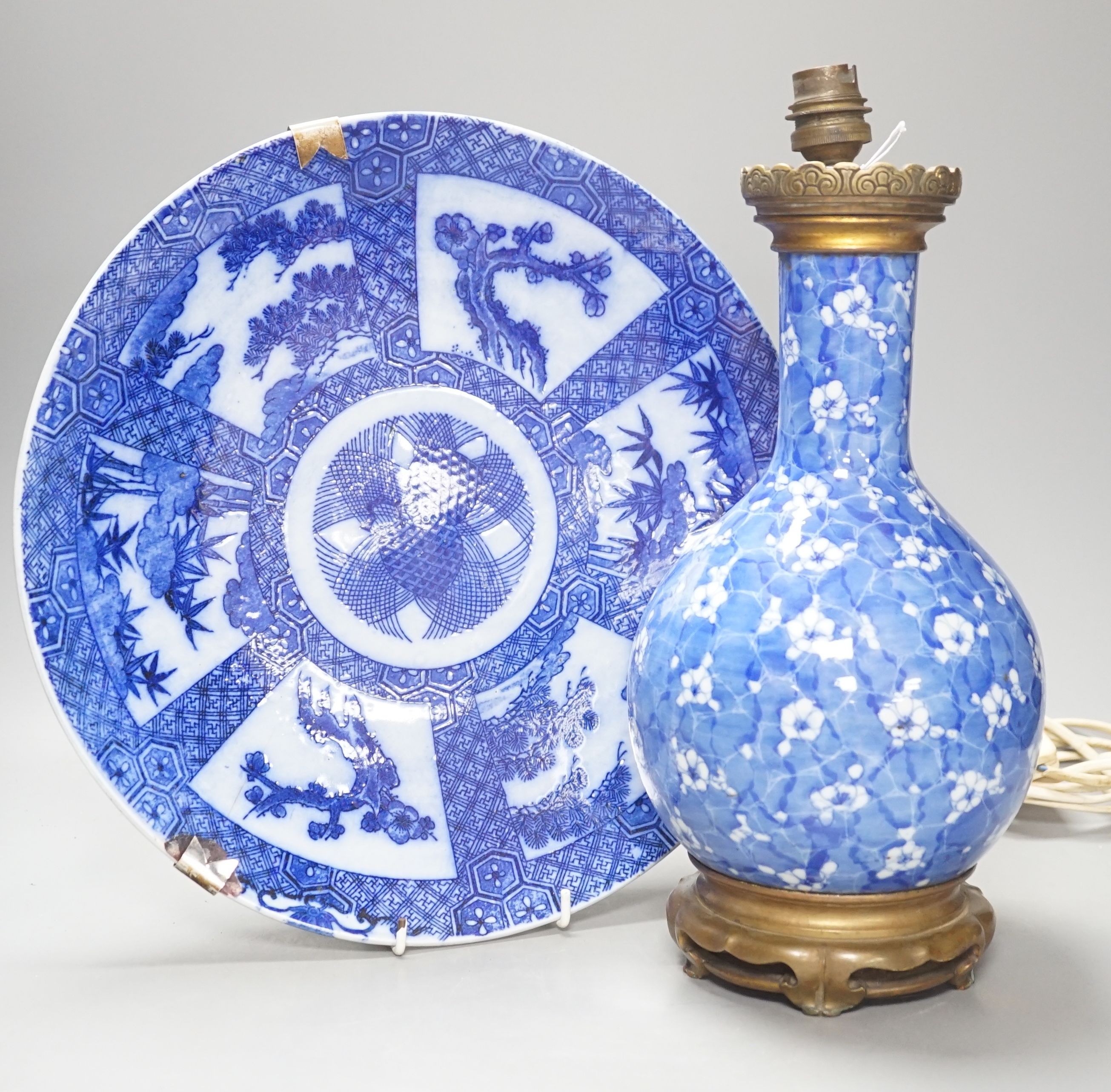 A Japanese prunus blue and white vase now as a lamp, together with a blue and white charger, 34cm diameter